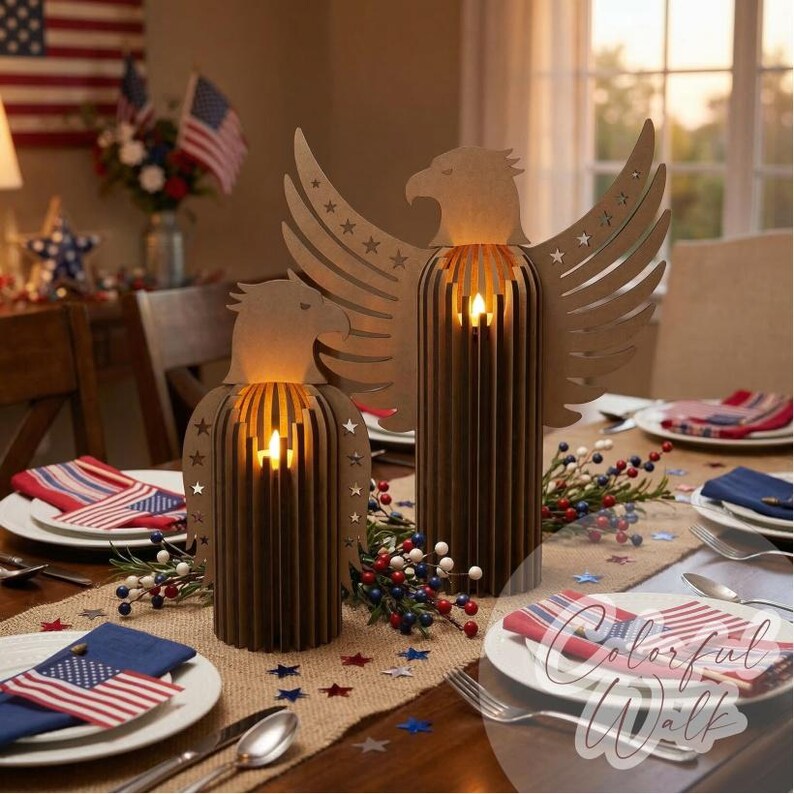 May include: Two brown wooden eagle-shaped candle holders with lit candles inside, set on a table decorated for a patriotic theme. The table setting includes American flags, star-shaped confetti, and red, white, and blue accents.