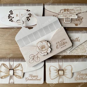 Puede incluir: Cajas de invitaci&oacute;n de madera cortadas con l&aacute;ser con varios dise&ntilde;os. Una presenta un dise&ntilde;o floral, otra un lazo y otras incluyen texto como "&iexcl;Feliz graduaci&oacute;n!" y "Reci&eacute;n casados".