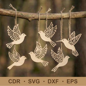 May include: Six wooden bird ornaments with intricate wing designs hang from a natural branch. Each bird is suspended by twine, showcasing detailed cut-out patterns. The ornaments are light brown, with the text "CDR • SVG • DXF • EPS" at the bottom.