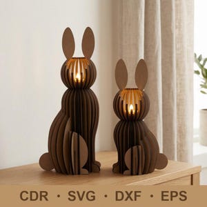 Puede incluir: Dos candelabros con forma de conejito de madera marrón con luces brillantes similares a velas en su interior. Las figuras de conejito están hechas de madera en capas, con orejas largas y un cuerpo redondo. El texto en la parte inferior de la imagen es: CDR, SVG, DXF, EPS.