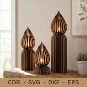 May include: Three wooden candle holders with a layered design, each with a unique shape and size. The candle holders are brown with vertical slats and a pointed top. The text "CDR • SVG • DXF • EPS" is at the bottom.