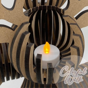 Puede incluir: Un portavelas decorativo de madera con un dise&ntilde;o en capas. El soporte presenta una vela LED blanca con una llama amarilla parpadeante. La estructura de madera tiene un aspecto de veta natural con acentos marr&oacute;n oscuro. El dise&ntilde;o es intrincado y art&iacute;stico.