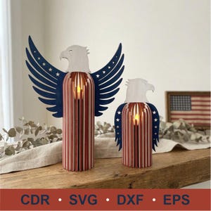 May include: Two wooden eagle candle holders with red, white, and blue accents. The wings are navy blue with white stars. The bodies are red and white striped. The text "CDR &bull; SVG &bull; DXF &bull; EPS" is at the bottom.