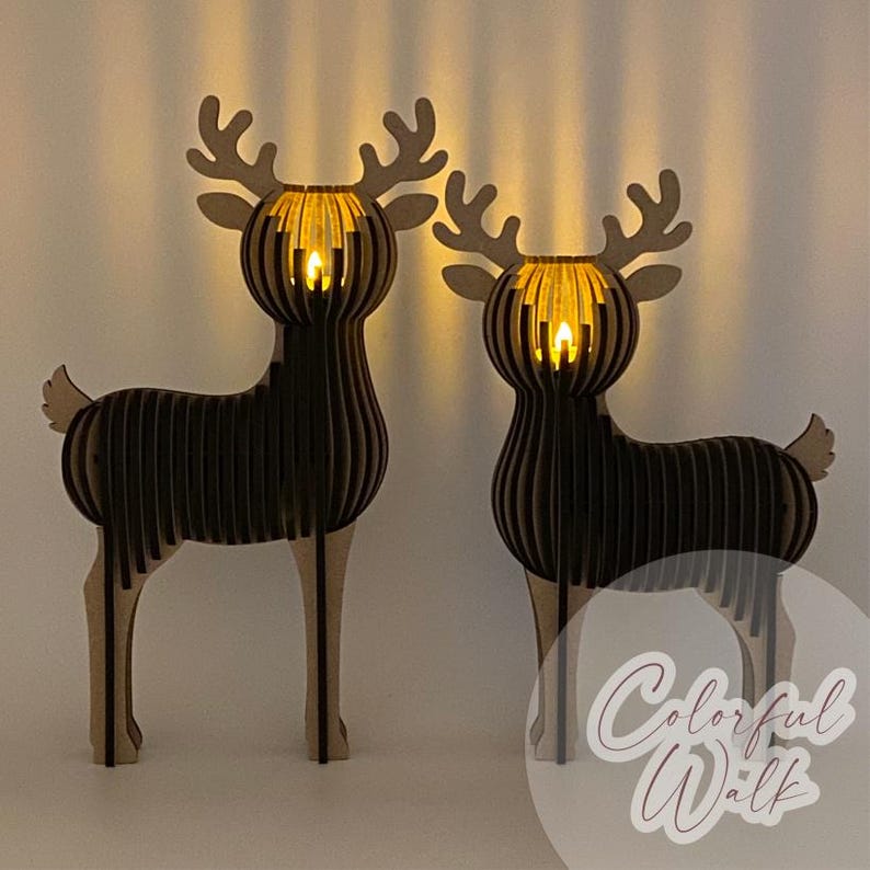 Puede incluir: Dos decoraciones de renos de madera con luces brillantes dentro de sus cabezas. Los renos est&aacute;n hechos de madera marr&oacute;n oscuro en capas con astas y patas de color marr&oacute;n claro. El texto "Colorful Walk" est&aacute; en la esquina inferior derecha.
