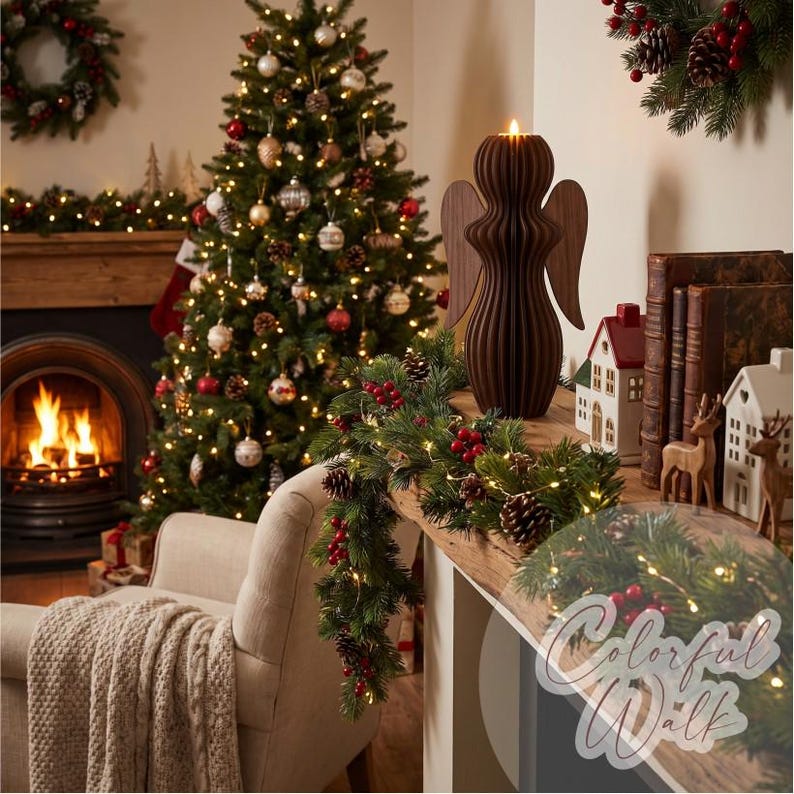 May include: A dark brown wooden angel figurine with a smooth, ribbed, vertical design and extended wings, featuring a small lit candle at the top. The angel is positioned on a wooden surface next to a green garland with red berries and pinecones.