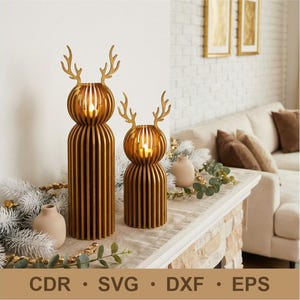 Puede incluir: Dos candelabros de madera con forma de reno, con un cálido acabado dorado. Los candelabros tienen un diseño ranurado y están rematados con cornamentas. La base de los candelabros es cilíndrica. También aparece el texto: CDR, SVG, DXF, EPS.