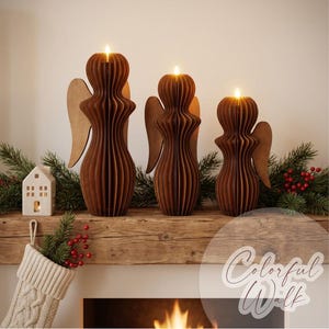 May include: Three brown wooden angel-shaped candle holders of varying heights, each featuring a ribbed, layered design and a lit candle at the top. The figures have flat, wing-like extensions on their sides and are arranged in a row.