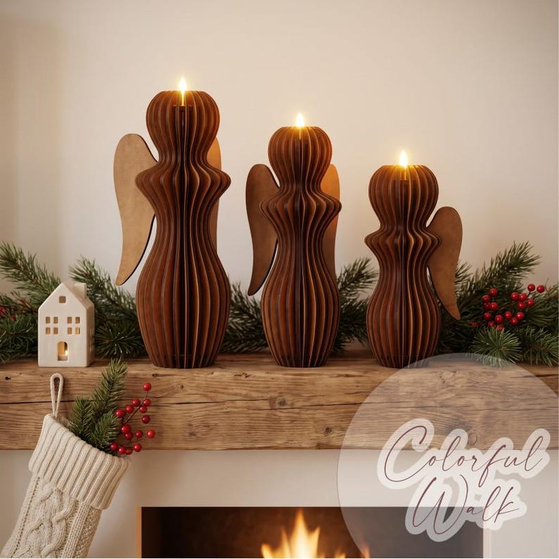 May include: Three brown wooden angel-shaped candle holders of varying heights, each featuring a ribbed, layered design and a lit candle at the top. The figures have flat, wing-like extensions on their sides and are arranged in a row.
