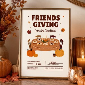 May include: A rectangular Friendsgiving invitation print in a gold frame. The design features a brown dining table with plates, chairs, pumpkins, and autumn leaves. Text includes "FRIENDS GIVING", "You're Invited!", event details, date, time, and contact information.