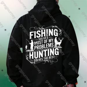 May include: Black hoodie with white text and graphics. The text reads "FISHING SOLVES MOST OF MY PROBLEMS HUNTING SOLVES THE REST". The graphic includes a fisherman, fish, deer, and trees. The hoodie has a drawstring hood.