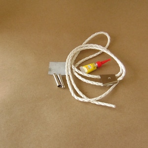 May include: A white braided cord with a silver clasp and two silver metal tips. A small tube of yellow glue with a red cap is also included.