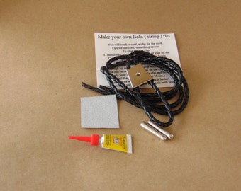 May include: A DIY kit for making a bolo tie. The kit includes a black braided cord, a silver metal bolo tie slide, two silver metal tips, a small tube of glue, and a piece of sandpaper. The instructions on the card read "Make your own Bolo (string) tie!"