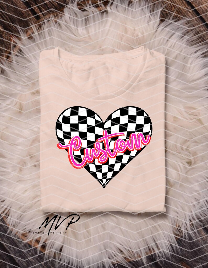 May include: A pink and white chequered heart with the word "Custom" in pink neon lettering. The heart is on a light pink t-shirt.