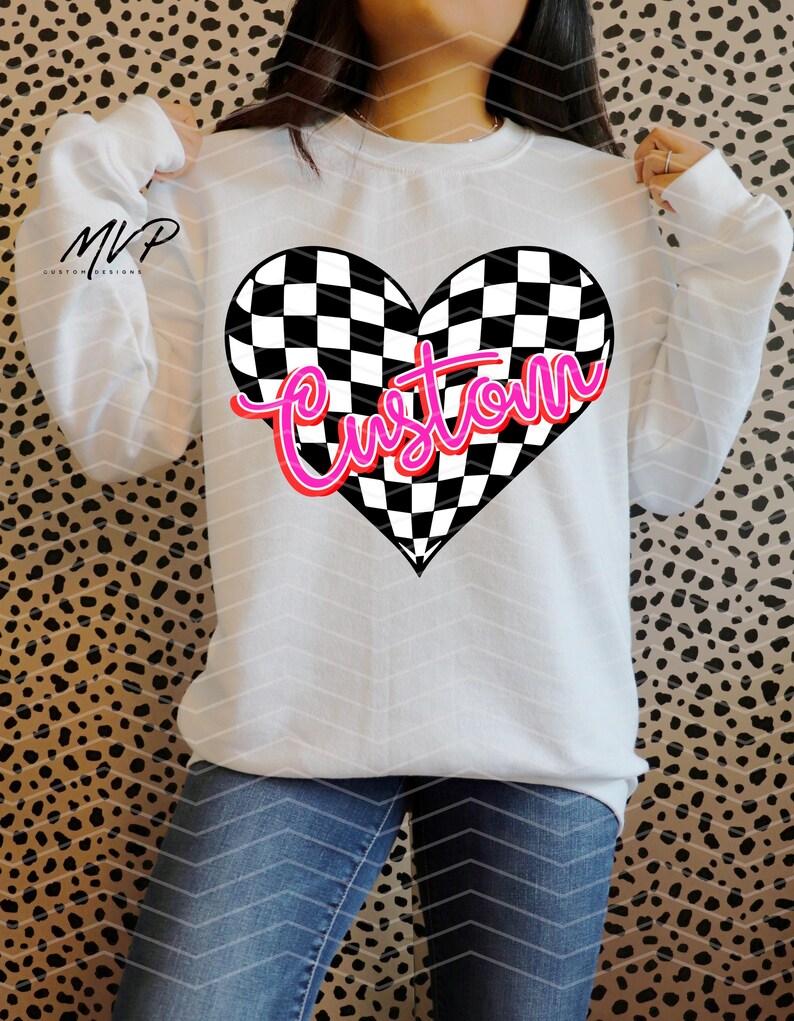 May include: White sweatshirt featuring a black and white chequered heart design with the word "custom" in pink lettering.