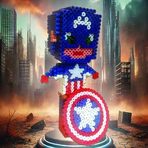May include: A red, white, and blue bead sprite of Captain America holding his shield. The sprite is standing on a black and blue platform against a backdrop of a destroyed city.