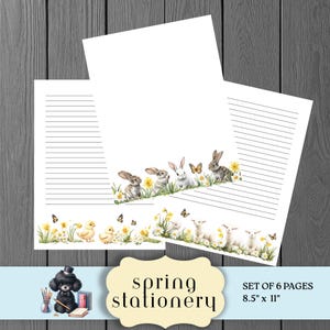 May include: Spring stationery set featuring lined paper with watercolor illustrations of bunnies, chicks, lambs, and butterflies. The bottom border has yellow flowers and green grass. The set includes 6 pages, each measuring 8.5 x 11 inches.
