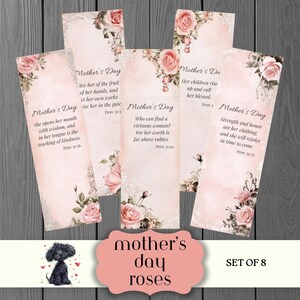 May include: Set of 8 Mother's Day bookmarks with floral rose designs and inspirational quotes. Each bookmark features a pink and white color scheme with decorative accents and text. The bookmarks are arranged on a dark wood surface.