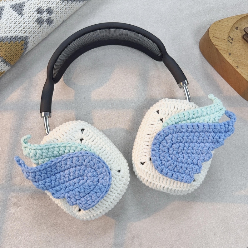 May include: White crocheted headphone covers with blue and green crocheted wings.