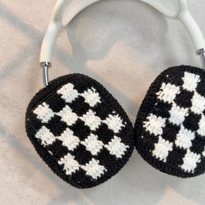 May include: White headphones with black and white checkered crochet earmuffs.