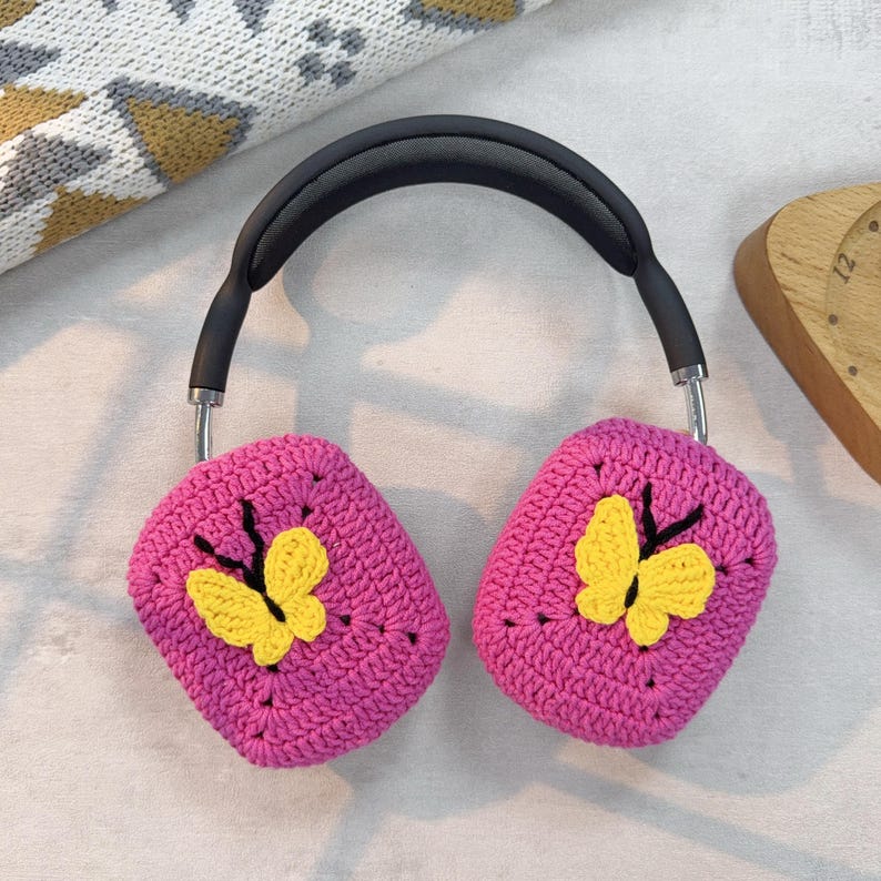May include: Pink crocheted headphone covers with yellow butterfly embellishments.