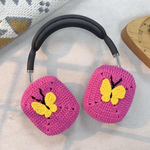 May include: Pink crocheted headphone covers with yellow butterfly designs.