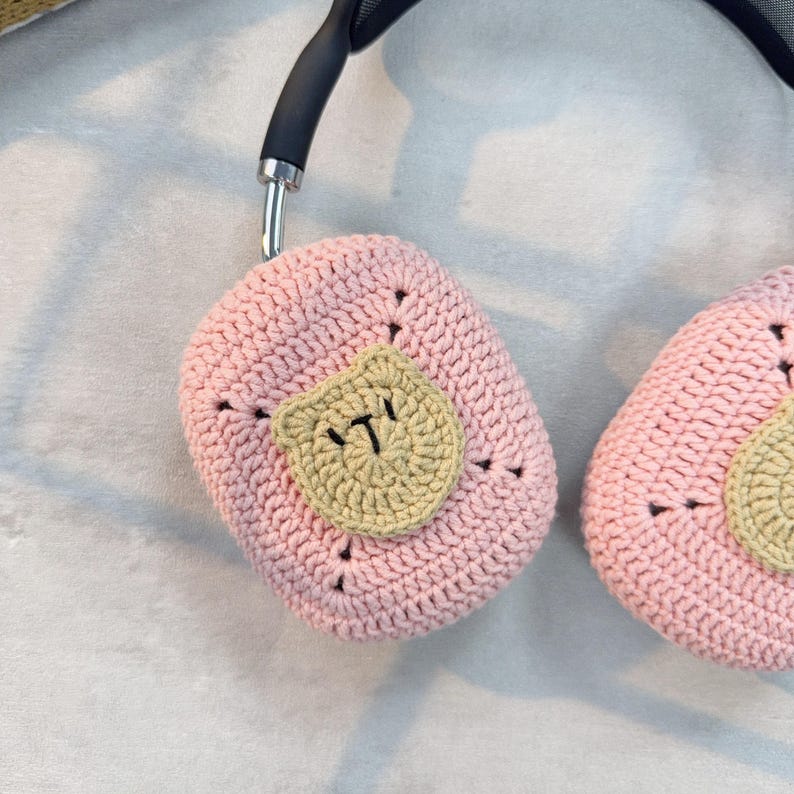 May include: Pink crocheted headphone covers with a brown crocheted patch that says "ITI" on each cover.