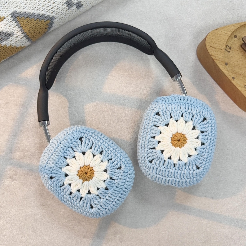 Puede incluir: Un par de fundas para auriculares de crochet azul con un dise&ntilde;o de margarita blanca. Las fundas est&aacute;n hechas con un hilo suave y texturizado y presentan un patr&oacute;n de margarita en relieve.