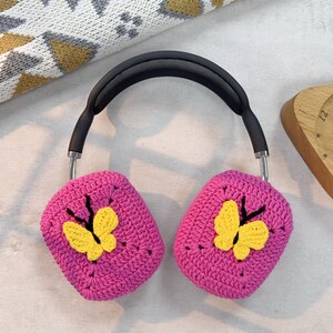 May include: Pink crocheted headphone covers with yellow butterfly embellishments.