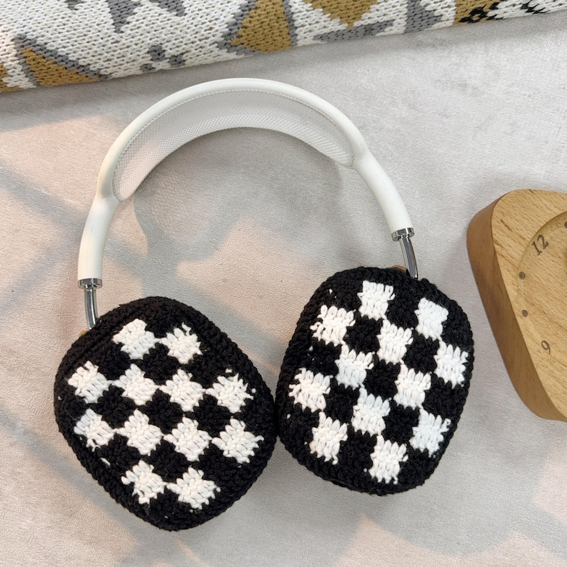 May include: White headphones with black and white checkered crochet earmuffs.