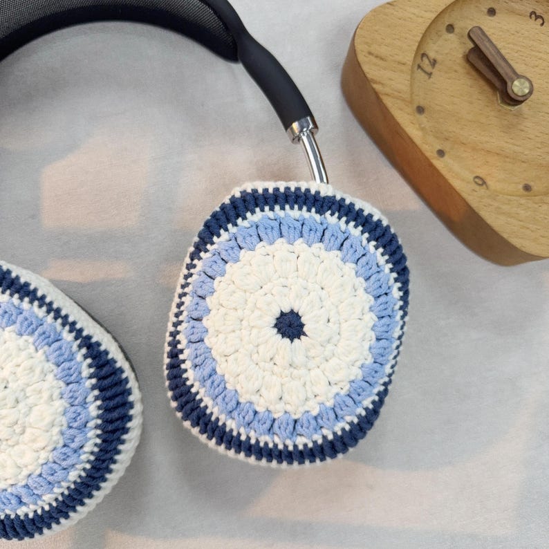 Puede incluir: Un par de fundas para auriculares de ganchillo en blanco, azul claro y azul oscuro. Las fundas presentan un dise&ntilde;o circular con un centro blanco y anillos conc&eacute;ntricos de azul claro y azul oscuro.
