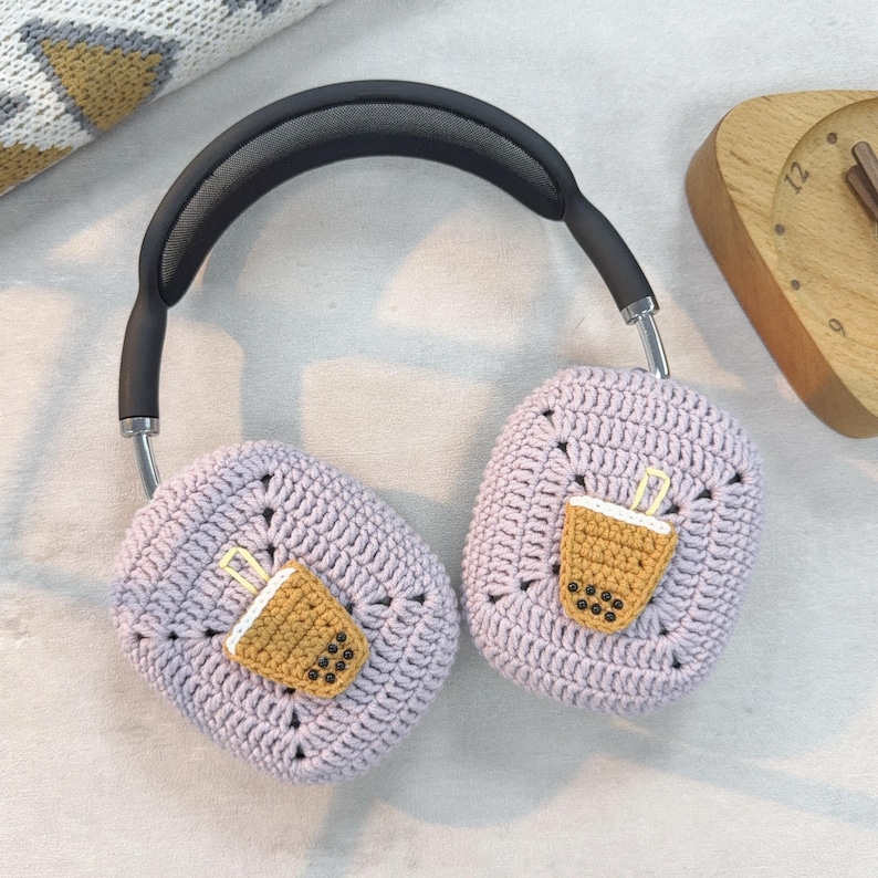 May include: Purple crocheted headphone covers with a brown and white boba tea design.