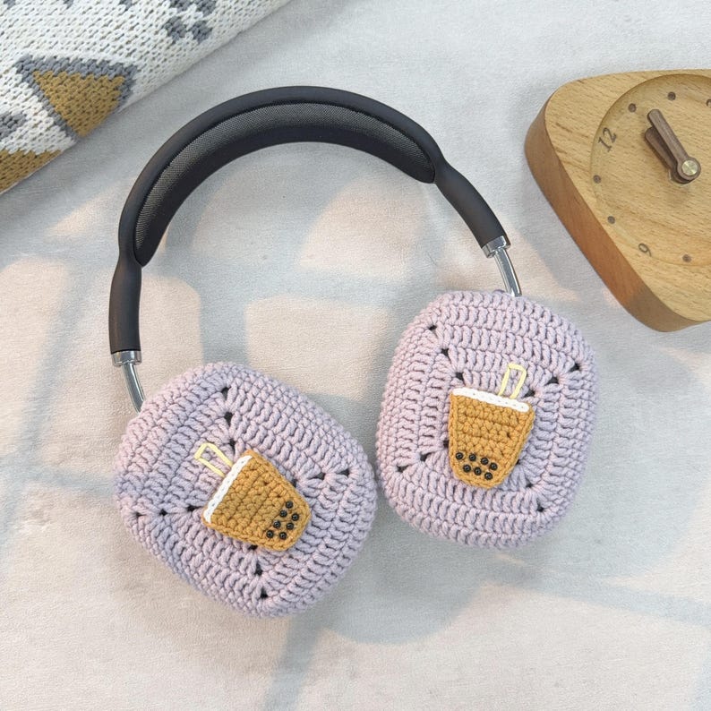 May include: Purple crocheted headphone covers with a brown crocheted boba tea design on each earcup.