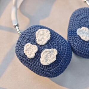 May include: Blue crocheted headphone covers with white cloud designs.