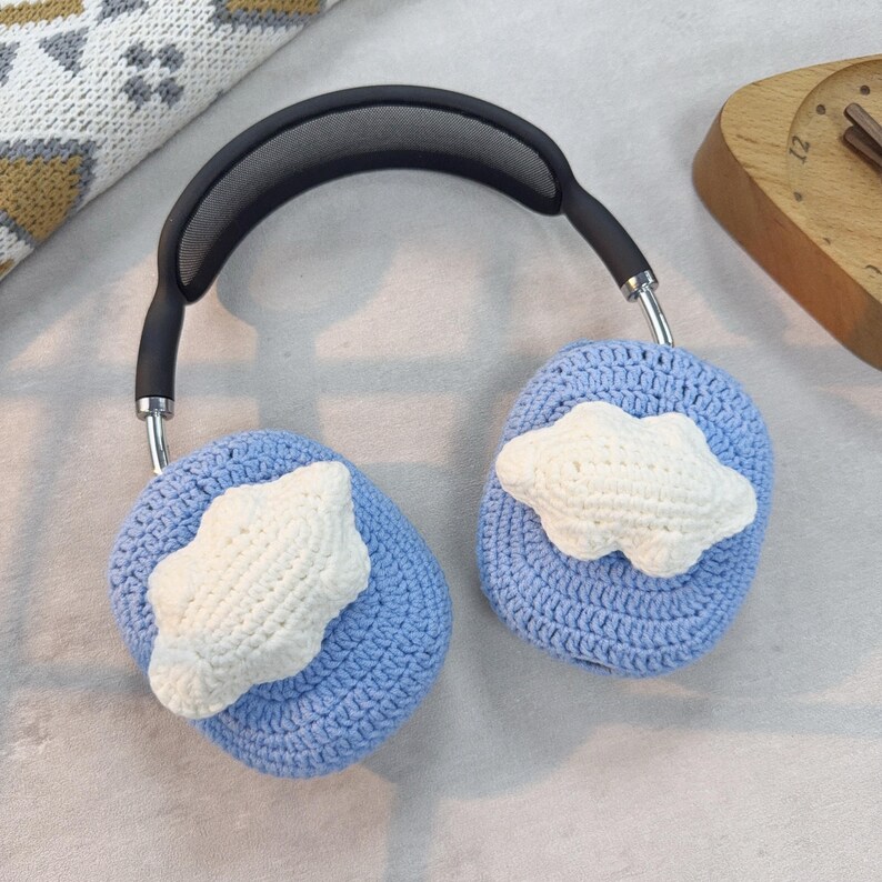 May include: Blue crocheted headphone covers with white crocheted cloud designs.