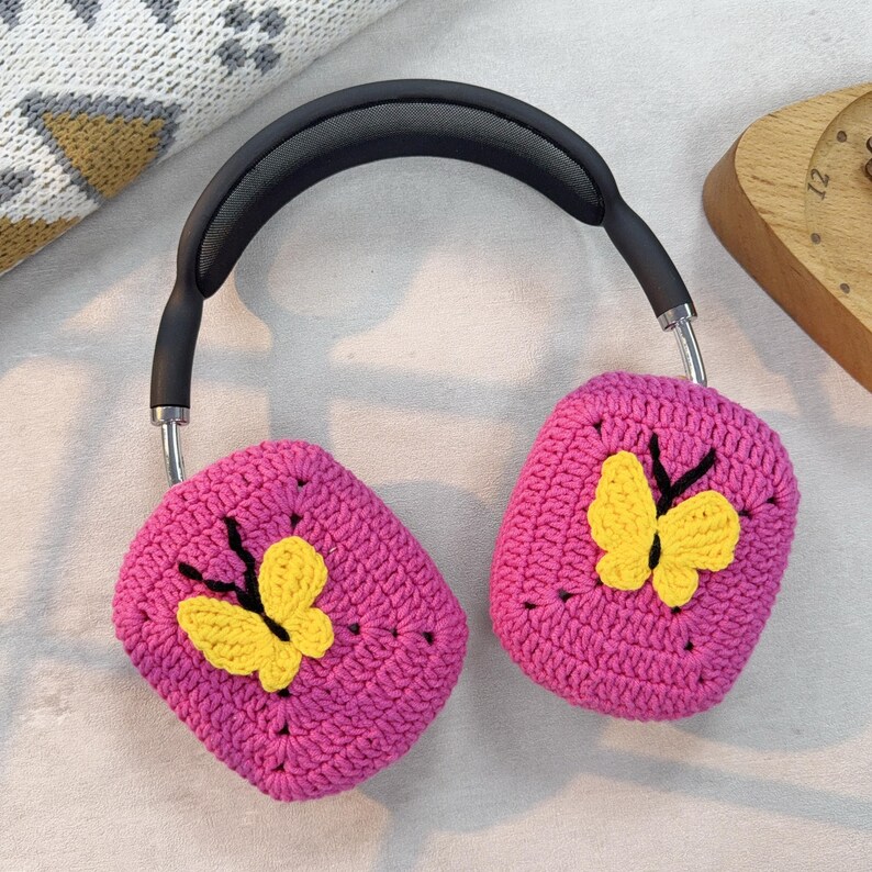 May include: Pink crocheted headphone covers with yellow butterfly embellishments.