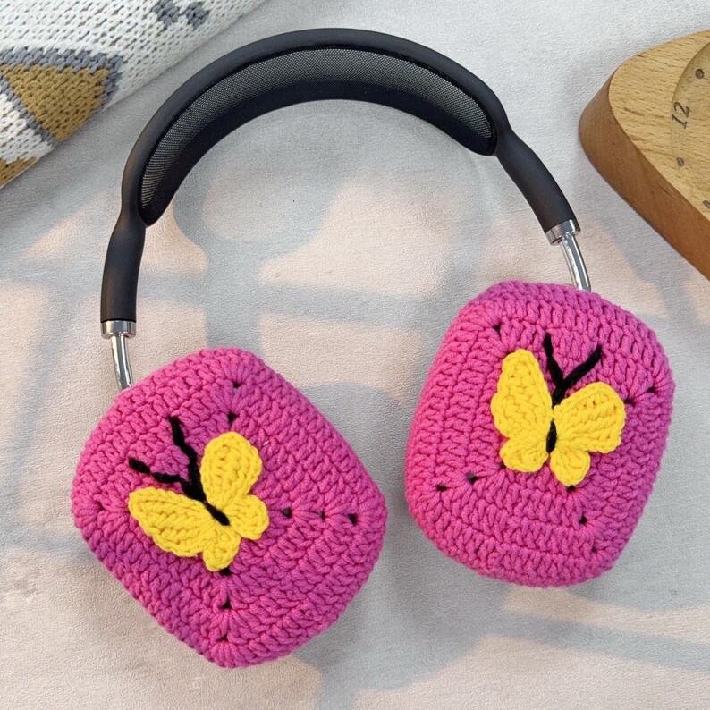 May include: Pink crocheted headphone covers with yellow butterfly embellishments.