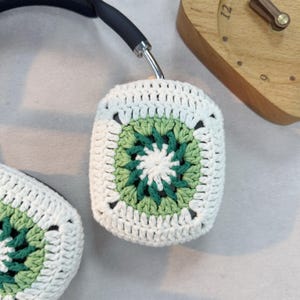 May include: White crocheted headphone covers with a green and white geometric pattern.