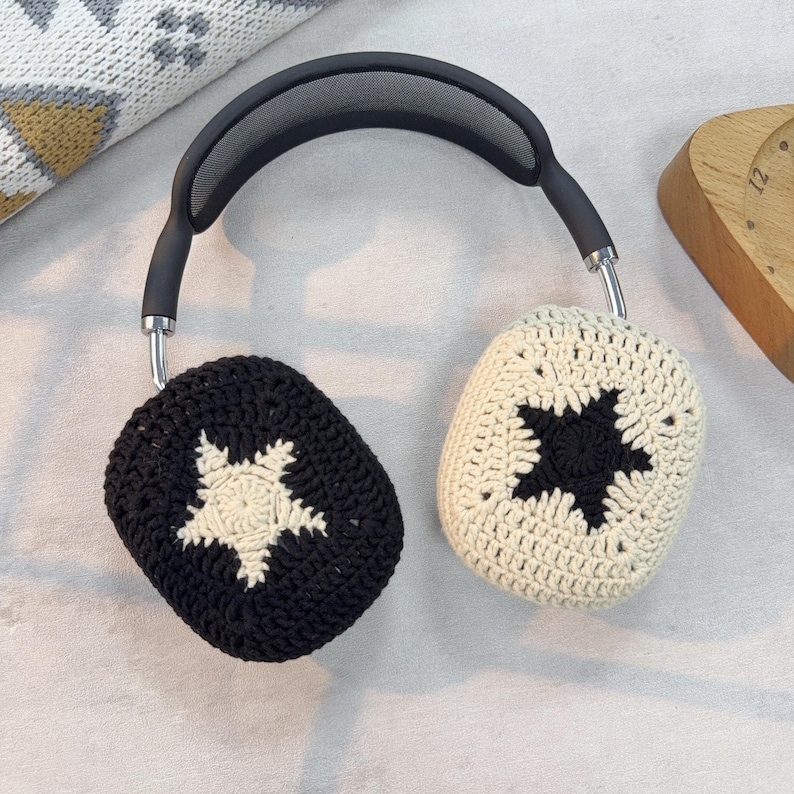 Peut inclure: Une paire de housses de casque crochet&eacute;es noires et blanches avec un motif d'&eacute;toile. Les housses sont faites d'un fil doux et textur&eacute; et sont con&ccedil;ues pour s'adapter aux oreillettes des casques.