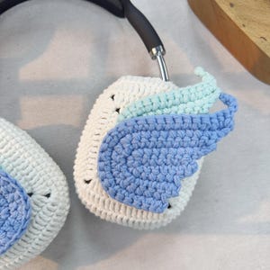 May include: White crocheted headphone covers with blue and light blue crocheted wings.
