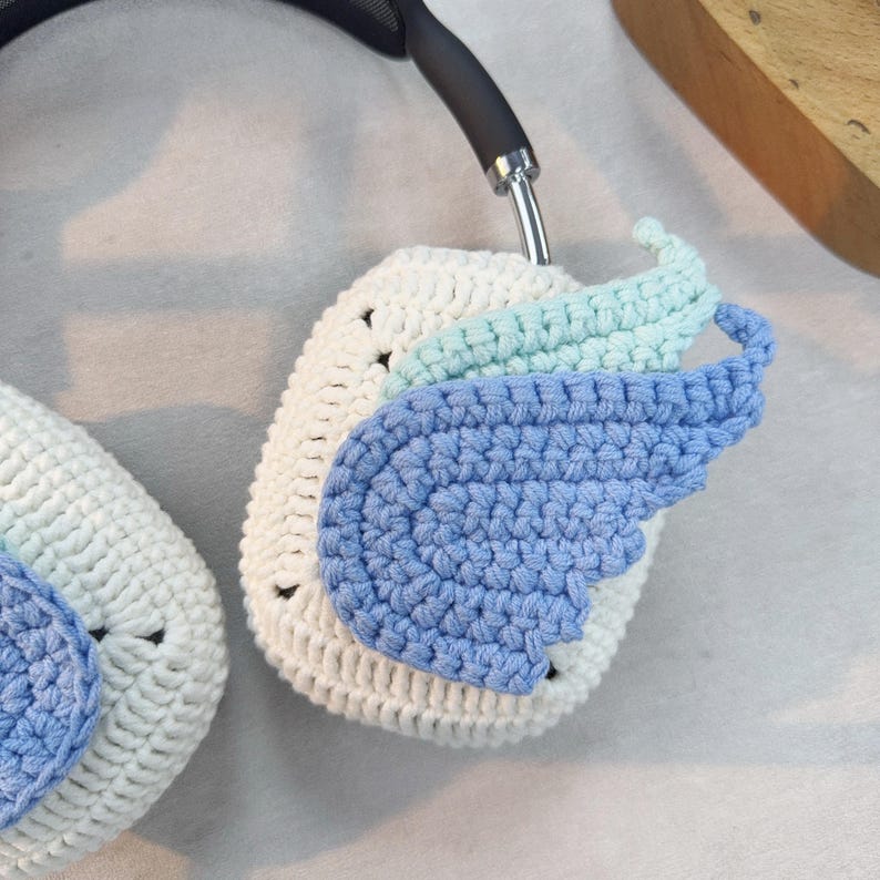 May include: White crocheted headphone covers with blue and light blue crocheted wings.