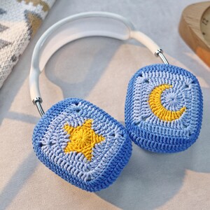 Puede incluir: Orejeras de ganchillo azules con un dise&ntilde;o de estrella amarilla y media luna.