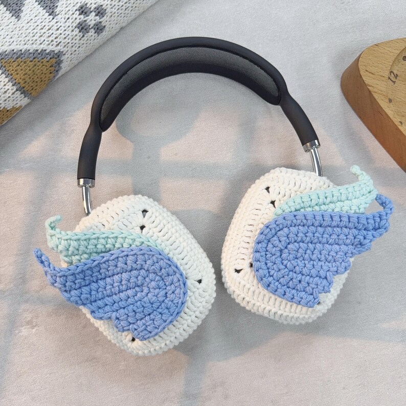 May include: White crocheted headphone covers with blue and light blue wings.