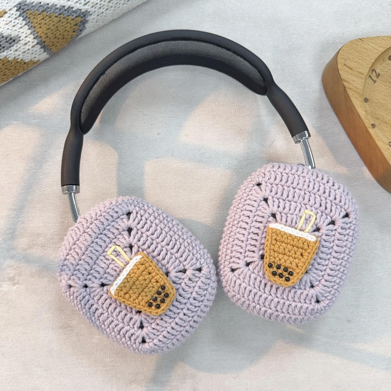 May include: Purple crocheted headphone covers with a brown and black boba tea design.