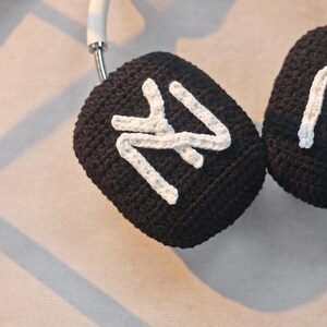 May include: Black crocheted headphone covers with white crocheted 'NY' lettering.