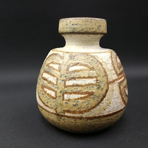 Könnte beinhalten: Eine kleine, runde Keramikvase mit einem braunen, weißen und grünen geometrischen Muster. Die Vase hat einen schmalen Hals und einen breiten Boden.