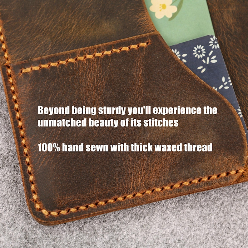 Op de afbeelding: Een bruine lederen hoes met dikke, lichtgekleurde handgestikte gewaxte draad. Het leer heeft een getextureerde, verweerde afwerking. De tekst op het object luidt: Beyond being sturdy you'll experience the unmatched beauty of its stitches 100% hand sewn with thick waxed thread.