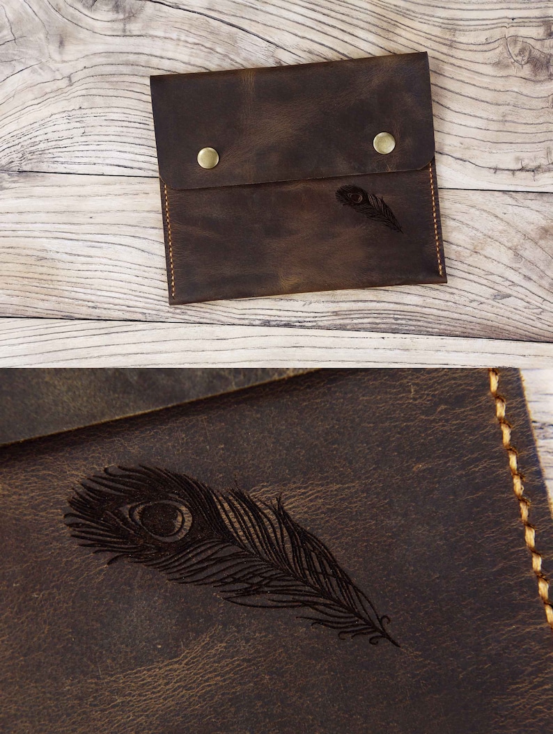 Puede incluir: Una bolsa de cuero marr&oacute;n con cierre de solapa y dos broches de lat&oacute;n. La bolsa tiene un dise&ntilde;o de pluma de pavo real grabado en la parte delantera.