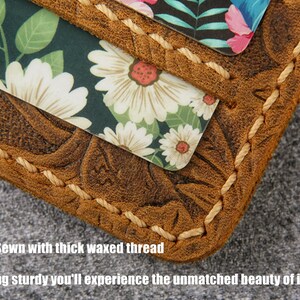 May include: Close-up of a brown leather wallet with a floral pattern embossed on the surface. The wallet is stitched with a thick, waxed thread. The text "100% Hand Sewn with thick waxed thread" and "Beyond being sturdy you'll experience the unmatched beauty of its stitches!" is visible below the wallet.
