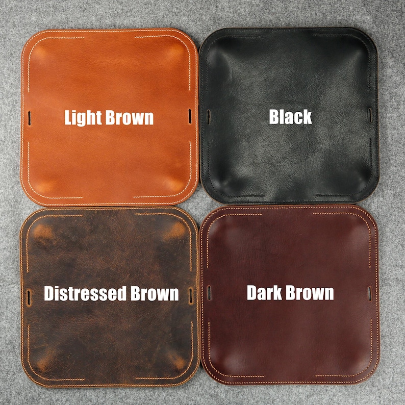 Puede incluir: Cuatro bandejas de cuero en diferentes colores: marr&oacute;n claro, negro, marr&oacute;n desgastado y marr&oacute;n oscuro. Cada bandeja tiene forma cuadrada con bordes ligeramente elevados y un borde cosido.