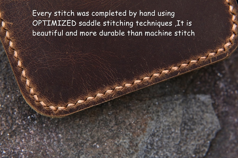 Op de afbeelding: Een donkerbruin lederen item met lichtgekleurde, met de hand genaaide zadelsteken langs de afgeronde rand. De tekst op het oppervlak luidt: Every stitch was completed by hand using OPTIMIZED saddle stitching techniques ,It is beautiful and more durable than machine stitch